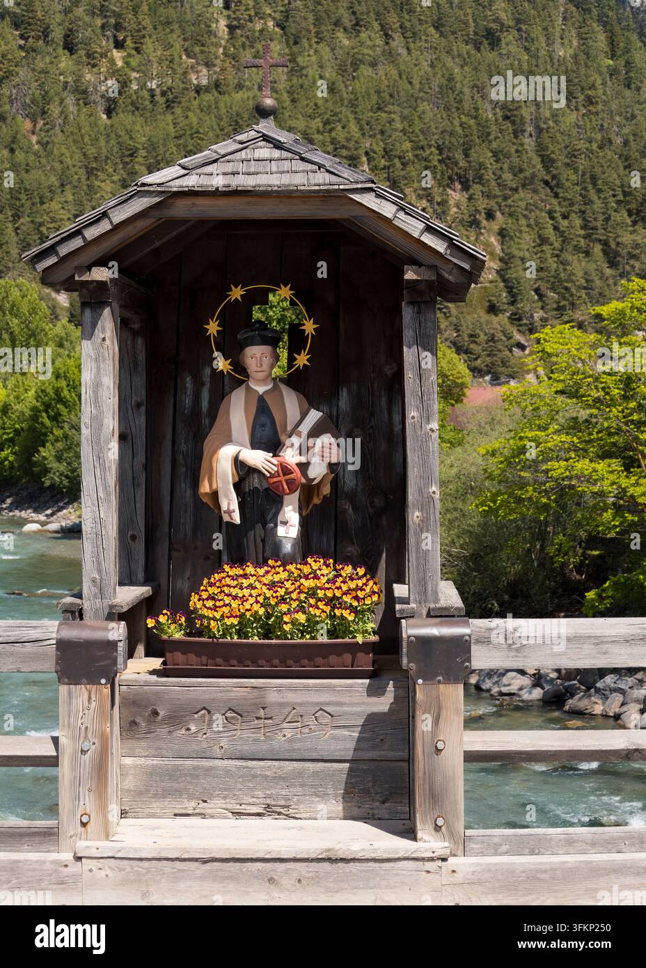 Schrein des heiligen Johannes von Nepomuk über einer alpinen Flussüberquerung (Pfunds, Österreich: 12. Mai 2026) Stockfoto