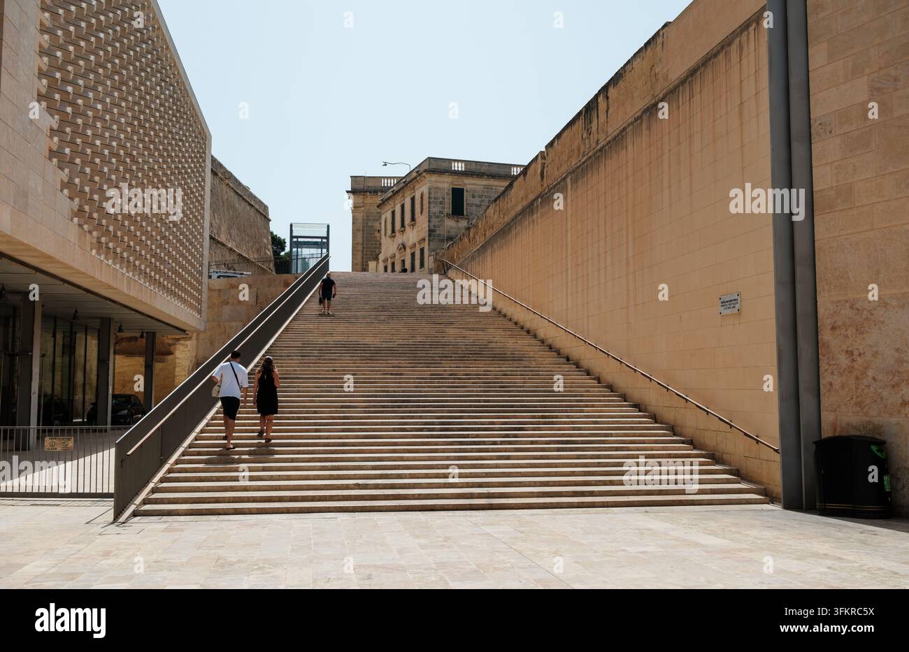 Lange, steile und breite Treppen neben dem Stadttoreingang von Valletta mit Menschen, die zur Straße Papst Pius V hinaufgehen Stockfoto