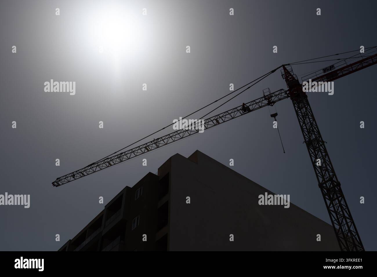 Ein Baubauturm, der sich vor einem sonnigen Himmel abhebt, mit Kopierraum und dem Rand eines Gebäudes. In Malta aufgenommen, kann aber als generisches Bild verwendet werden Stockfoto