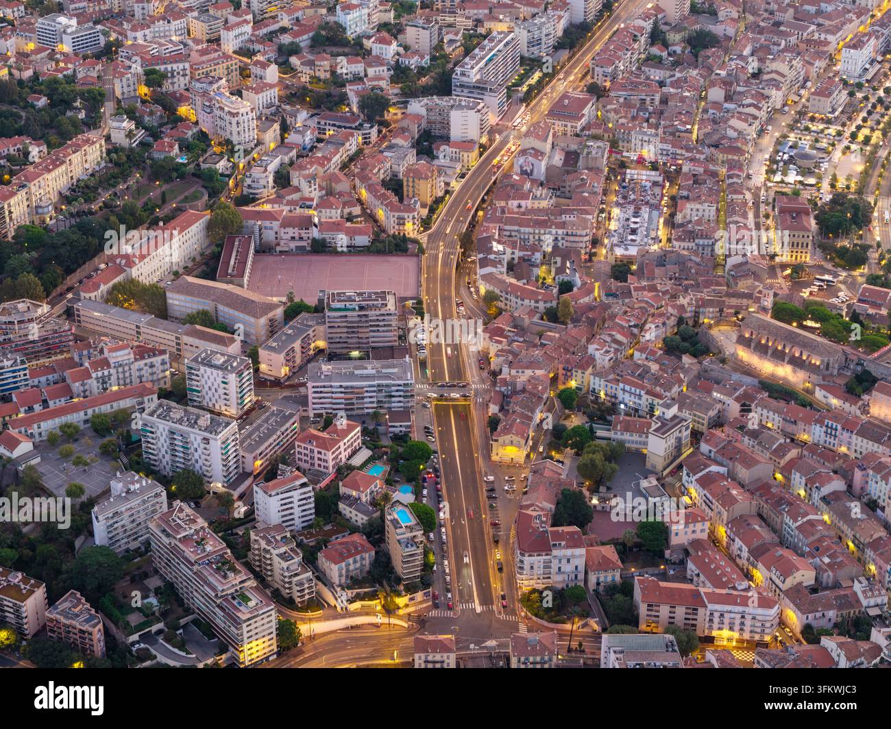 Luftbild der urbanen Landschaft von Cannes in der Dämmerung, mit beleuchteten Straßen und dichter Wohnarchitektur in Cannes, Provence-Alpes-Côte d Stockfoto