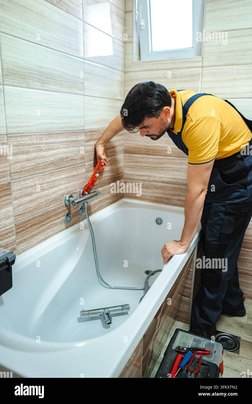 Klempner installiert einen neuen Duschhahn in einem Badezimmer Stockfoto