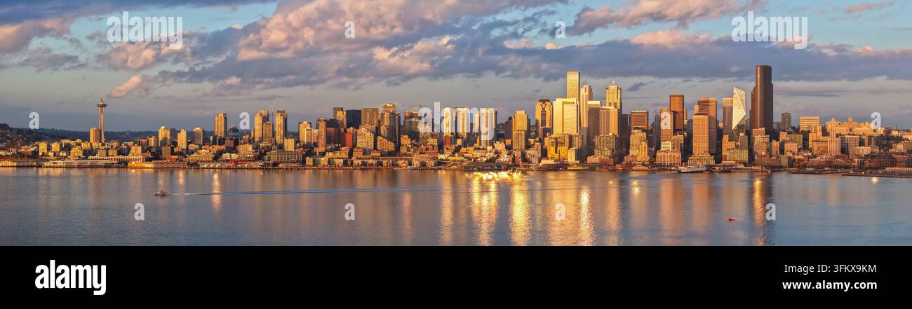 Luftbild der Skyline von Seattle mit dem Space Needle und Wolkenkratzern entlang der Uferpromenade bei Sonnenuntergang, wobei goldenes Licht auf dem Wasser reflektiert wird Stockfoto