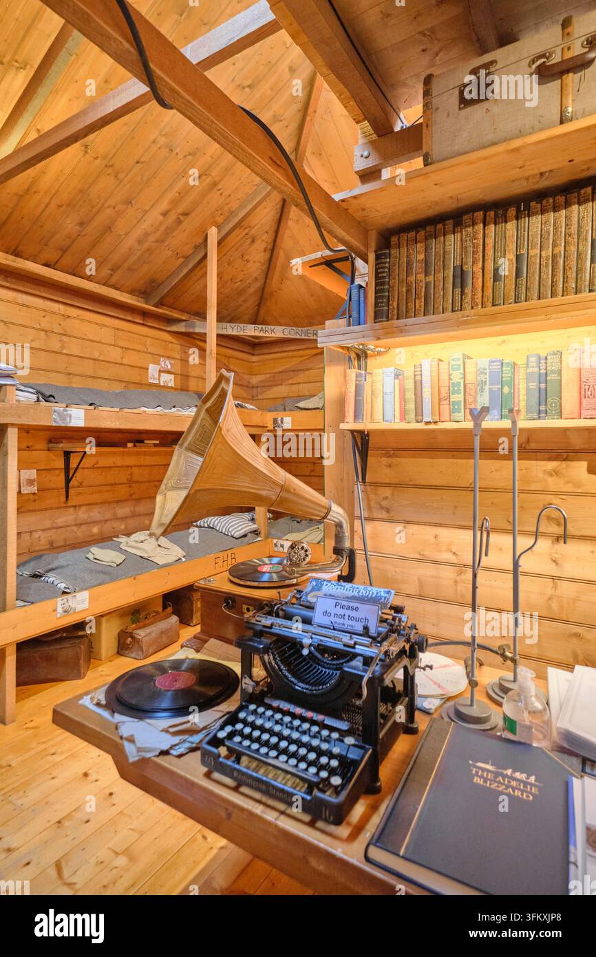 Ansicht des gemeinsamen Arbeitsbereichs mit Schreibmaschine, Grammophon, Landesflaggen und vielen Büchern. Im Mawson's Hut Museum in Hobart, Tasmanien, Australien. Stockfoto