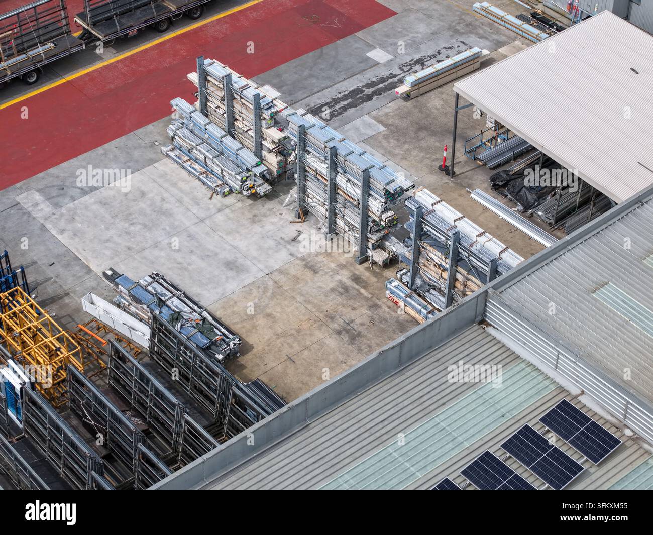 Luftbild eines Industriegeländes mit Metallregalen, Baumaterialien und Solarpaneelen auf einem Lagerhausdach in Melbourne, VIC, Australien. Stockfoto