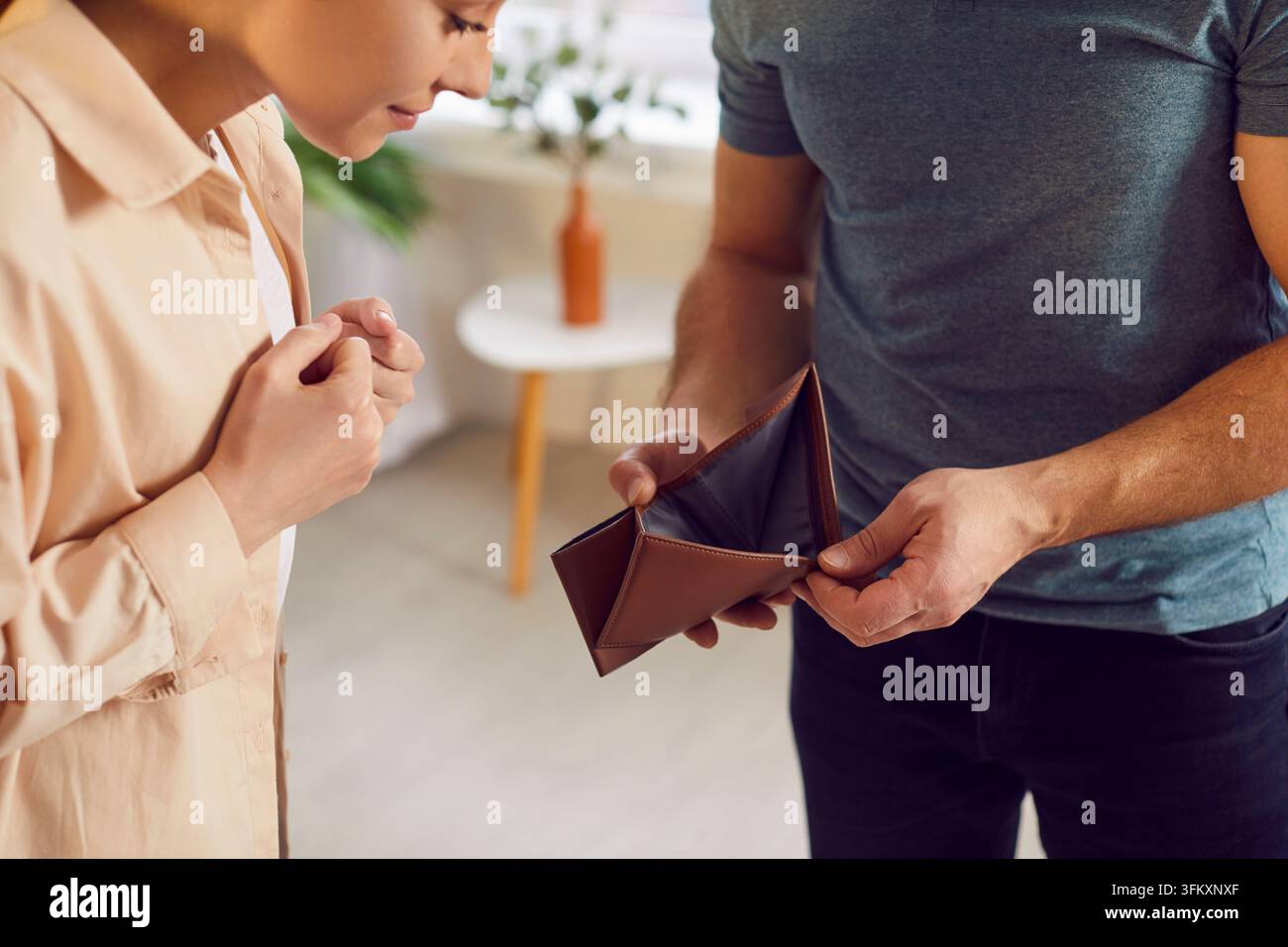 Ehemann zeigt Frau leere Brieftasche Stockfoto
