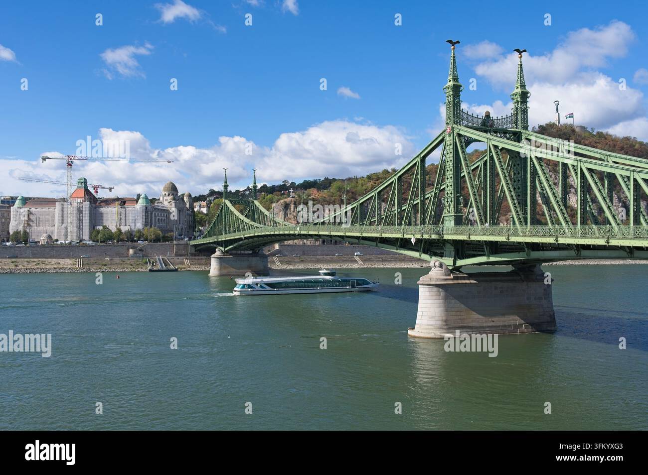Budapest, Ungarn – 21. September 2026: Die historische Freiheitsbrücke (Szabadság híd) spannt sich unter blauem Himmel über die Donau nahe dem Fővám tér. Stockfoto