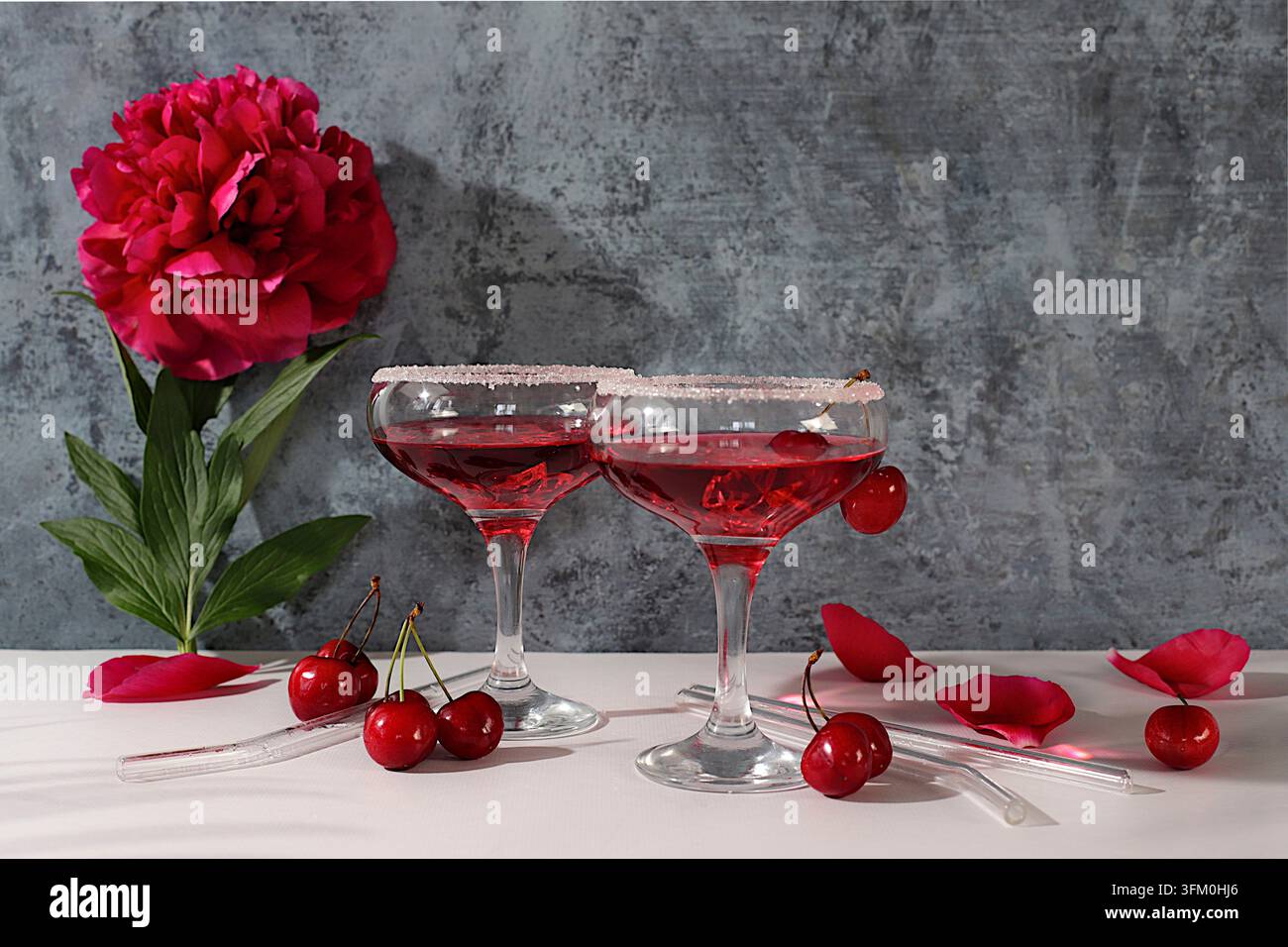 Eisloch mit Kirsche für eine Party, modernes Stillleben mit sommerlichen alkoholischen Cocktails und burgunderroten Pfingstrosen auf einem modernen sonnigen Hintergrund, minimalistisch Stockfoto