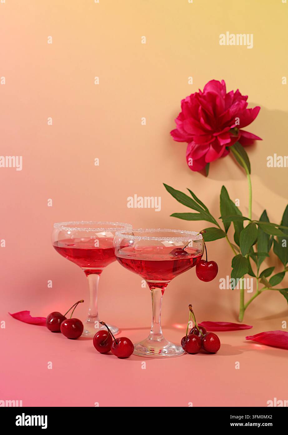 Eisloch mit Kirsche für eine Party, modernes Stillleben mit sommerlichen alkoholischen Cocktails und burgunderroten Pfingstrosen auf einem modernen sonnigen Hintergrund, minimalistisch Stockfoto