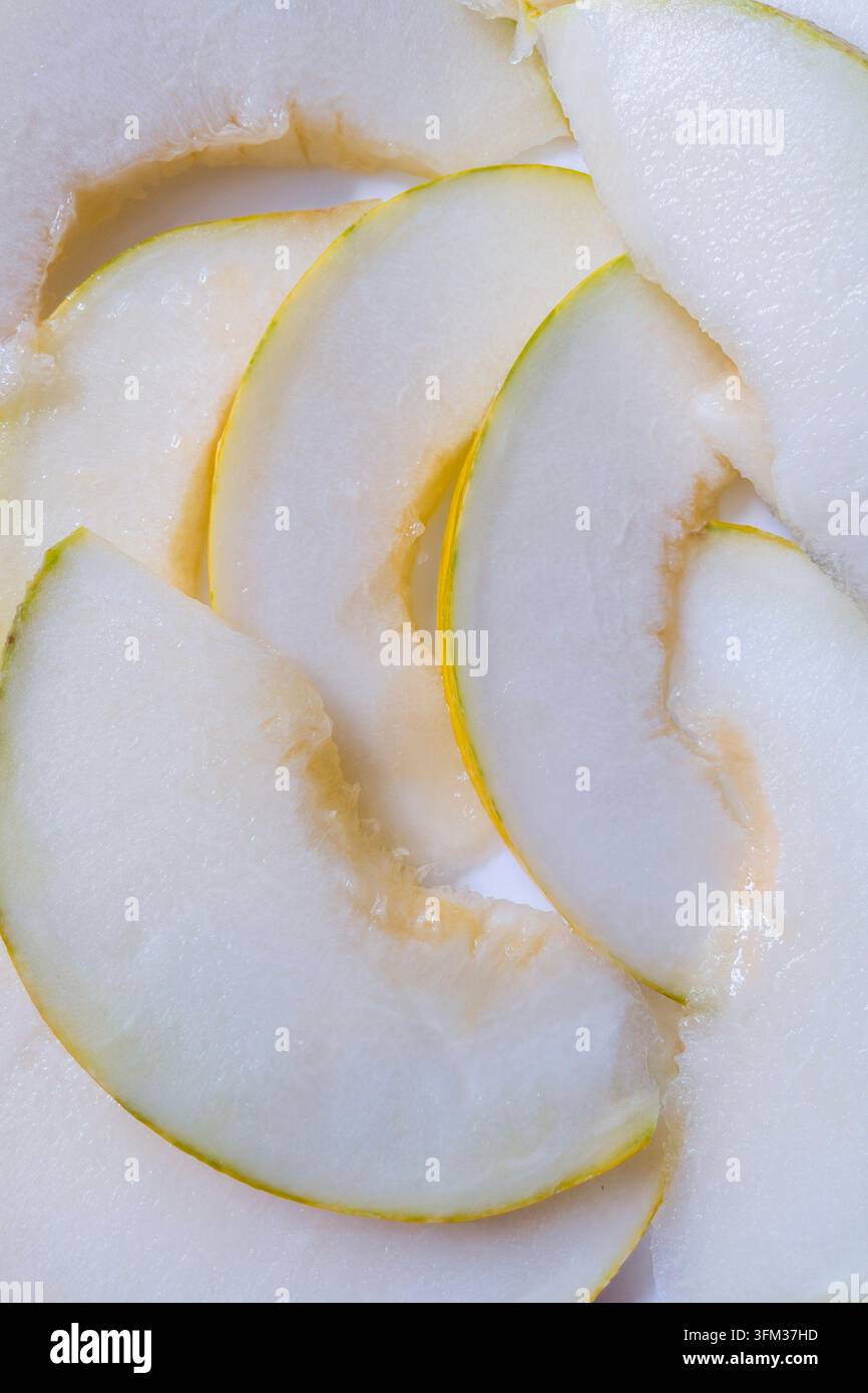 Frische saftige gelbe Melonenstücke auf weißem Hintergrund von oben - Smartphone-aufgenommenes Stockfoto