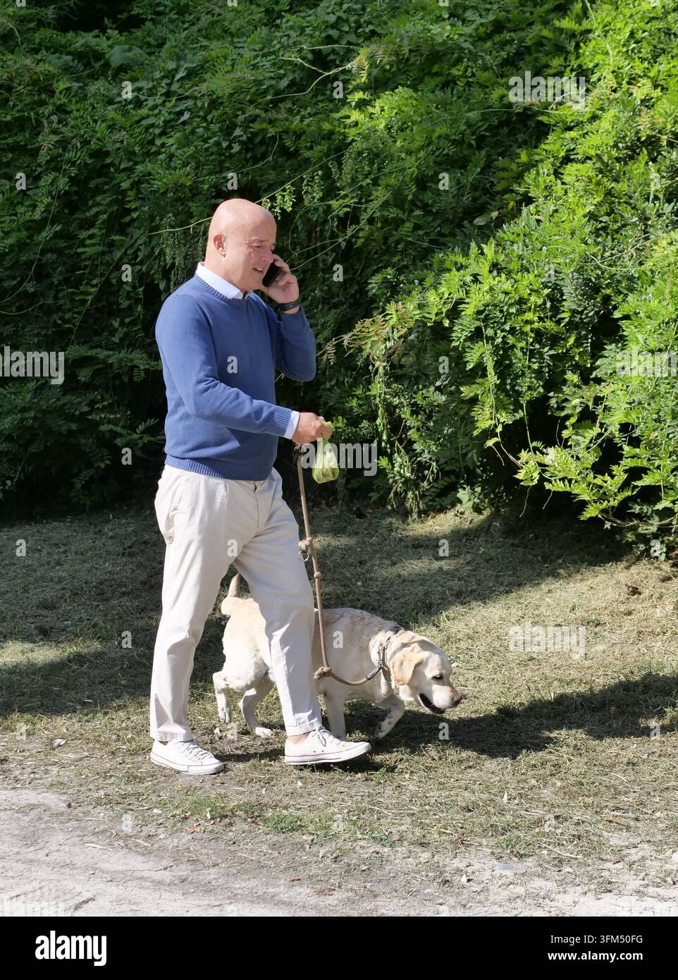IPA89021277 - Der renommierte Fernsehjournalist Gianluigi Nuzzi führt seinen Hund im Mailänder Sempione-Park spazieren Stockfoto