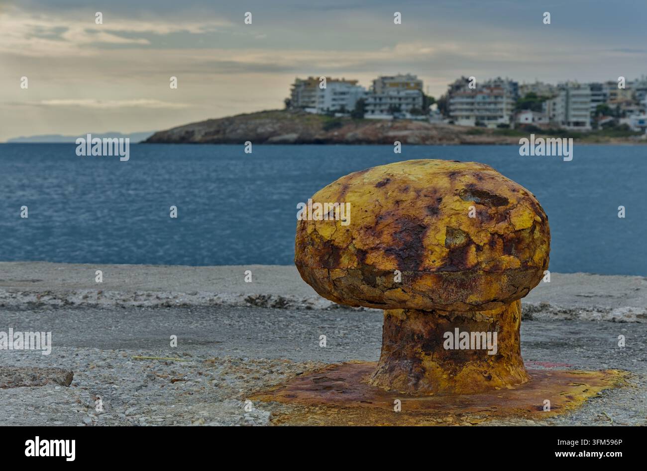 Verwitterter gelber Ankerbollwerk mit Rost, Korrosion und abblätternder Farbe im Hafen von Rafina, Ostattika, Griechenland. Stockfoto