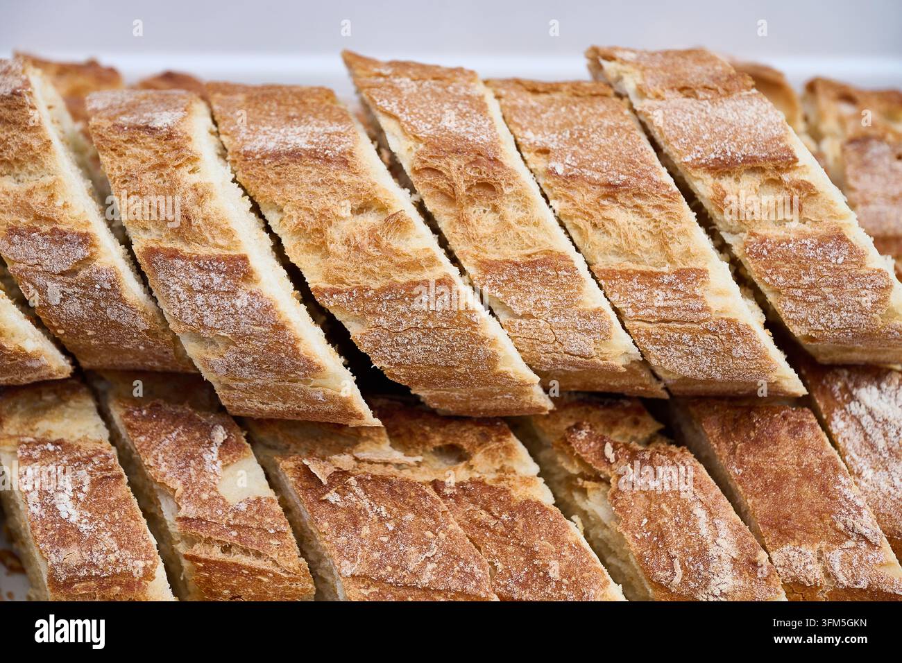 Knusprige französische Baguettescheiben mit goldbrauner Kruste und weicher weißer Krume, rustikales Backofenbrot ideal für Vorspeisen, Frühstück, Sandwiches oder als Sa Stockfoto