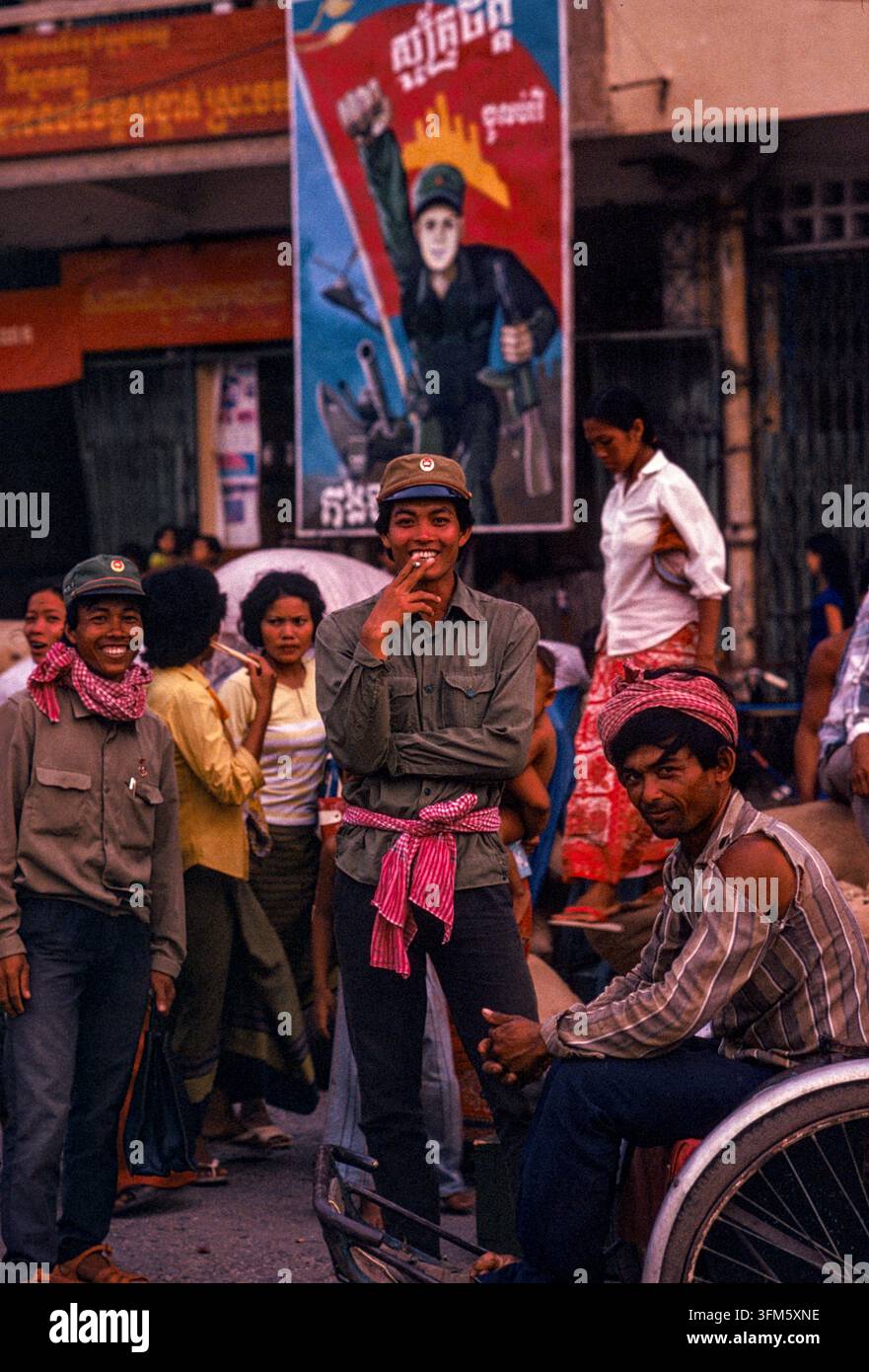 Menschen auf der Straße mit einem patriotischen Plakat im Hintergrund, Phnom Penh, Sept. 1988. g Stockfoto