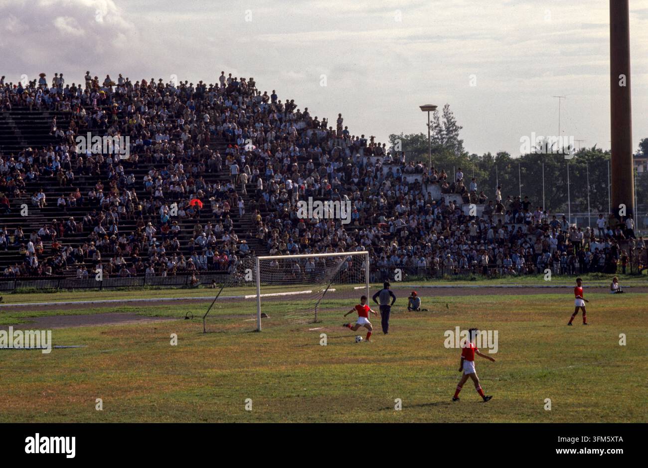 Leute, die ein Fußballspiel in Phnom Penh, Kambodscha, 1987 ansehen. Stockfoto