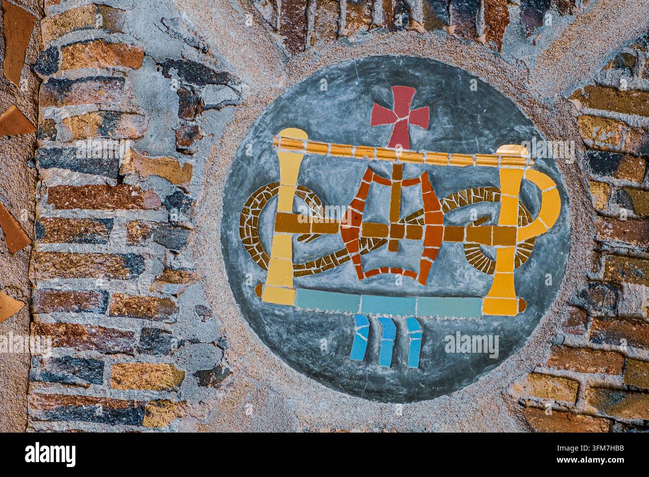 Abstraktes religiöses Mosaikemblem an einer rustikalen Wand Stockfoto