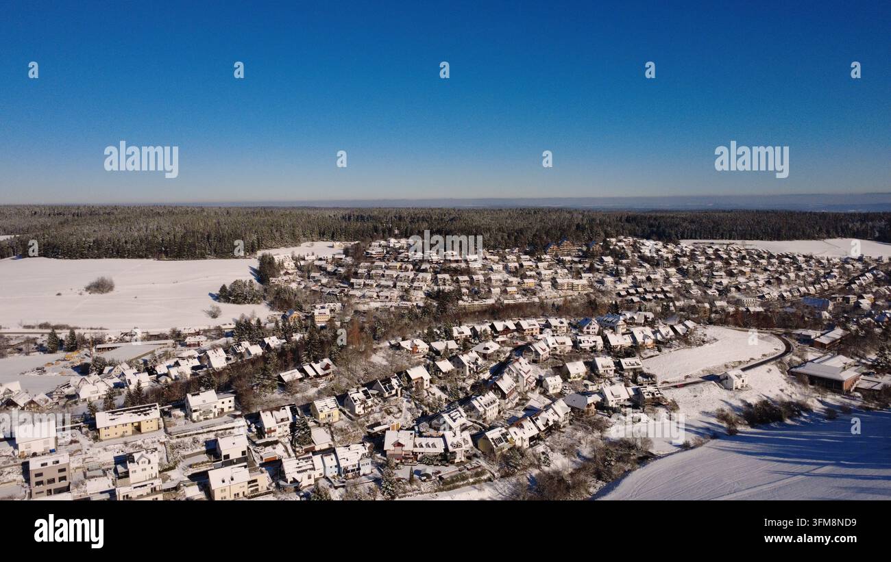Winterliche Landschaft in Deutschland mit schneebedeckten Feldern, entfernten Häusern, Straßen und Landschaften an einem kalten Novembertag. Stockfoto