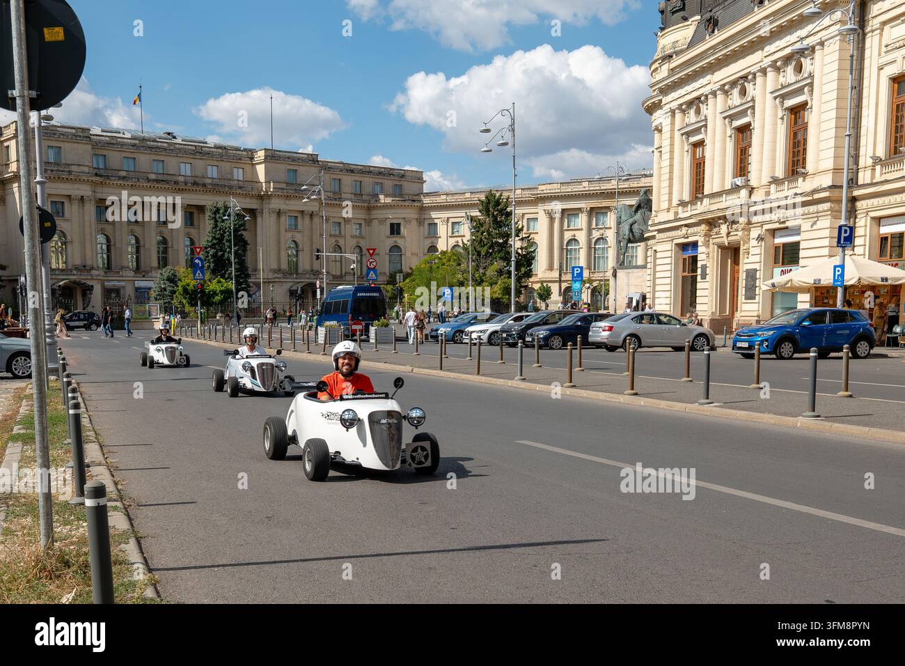 Miniatur-Hot-Rod-Autos fahren in einer städtischen Parade auf der Calea Victoriei neben dem historischen Universitätsbibliotheksgebäude in Bukarest Stockfoto