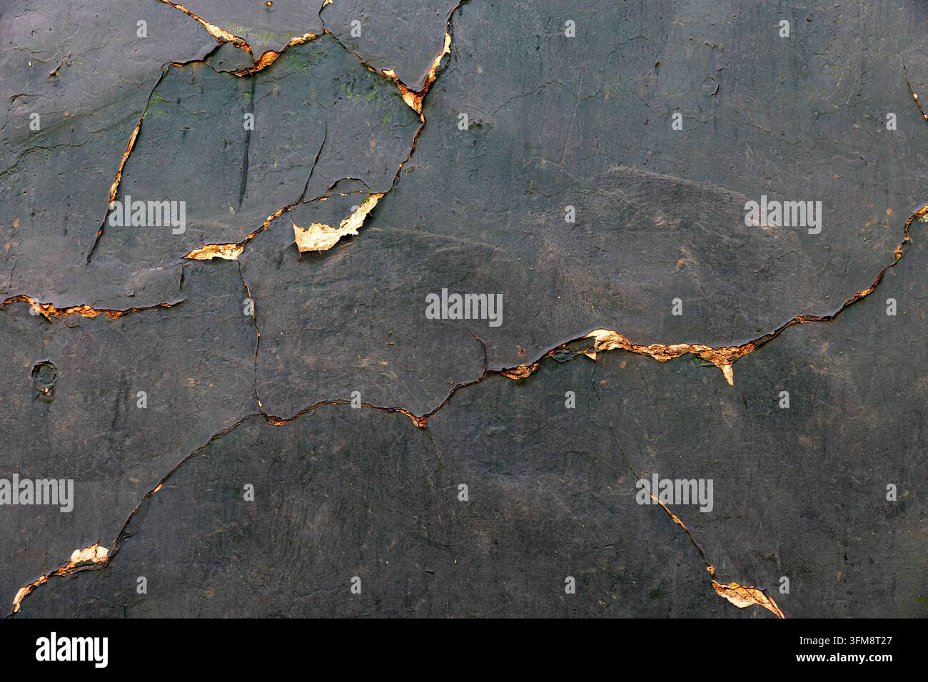 Abstrakte rissige dunkle Steintextur mit goldenen Details Stockfoto