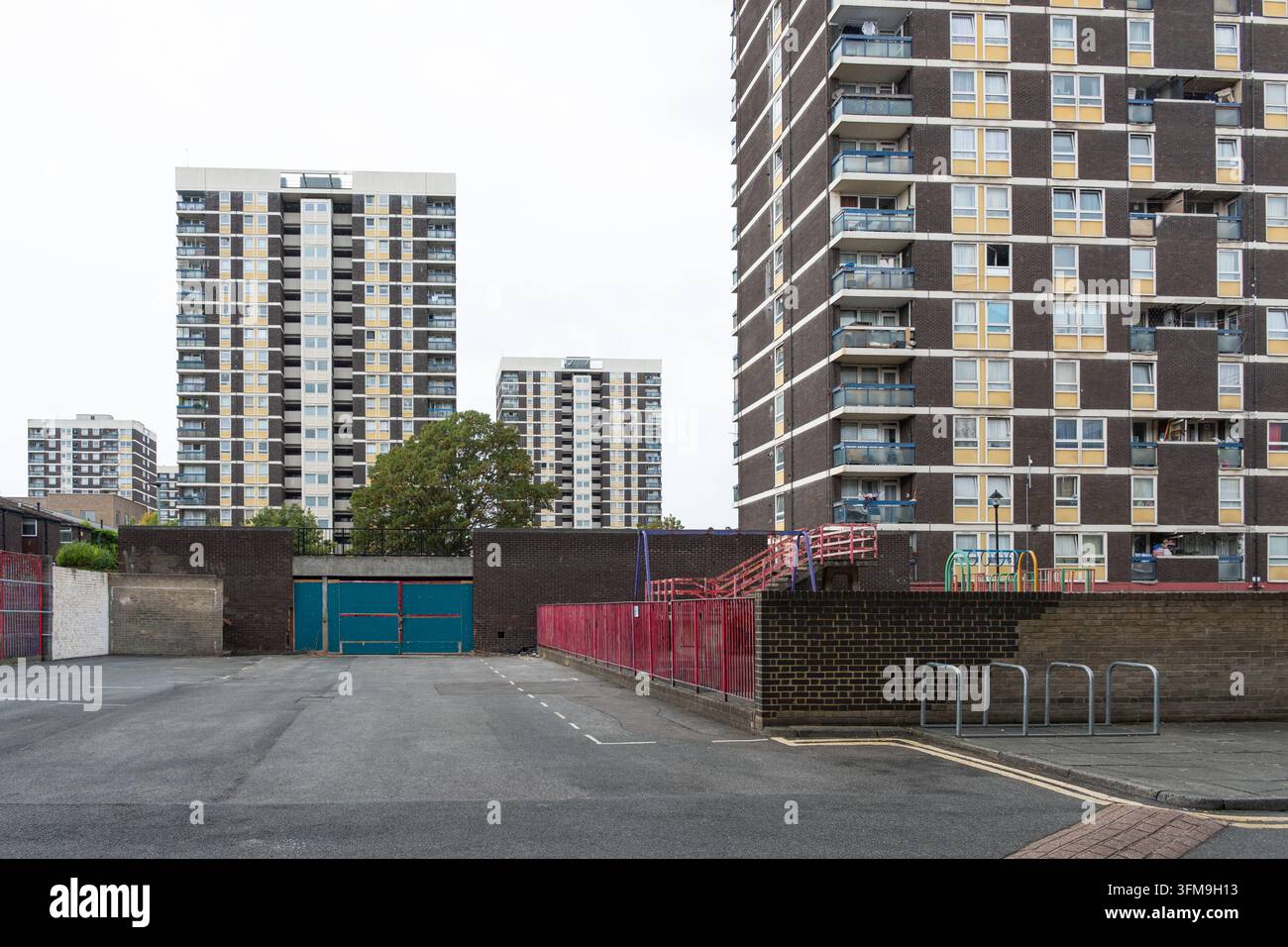 Wohnhaustürme des De Beauvoir Estate in Hackney, East London, gesehen von einem Parkplatz mit Wohnblocks und einem gemeinsamen Spielplatz. Stockfoto
