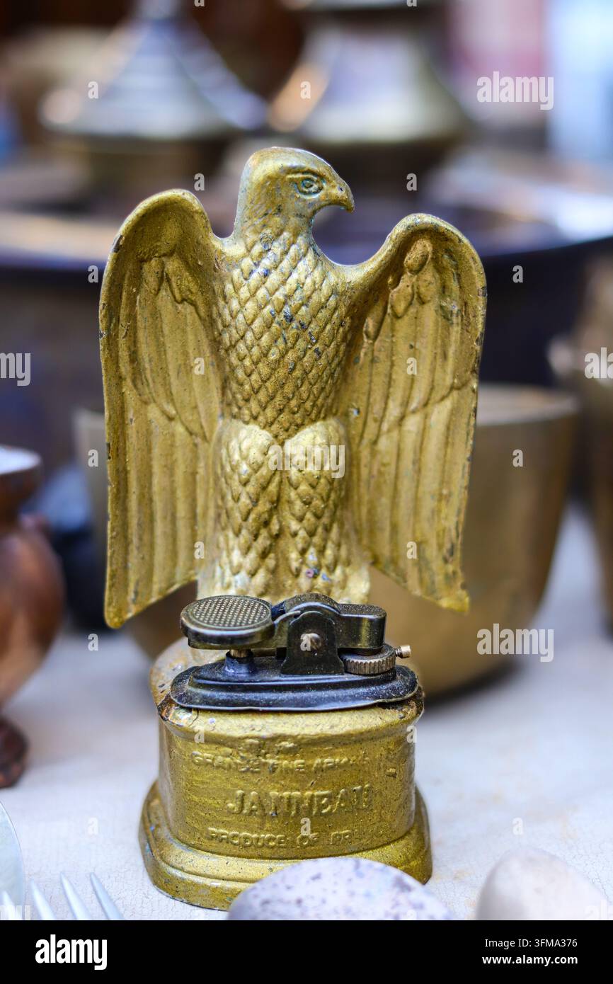 Adlerförmiger Janneau-Tischfeuerzeug mit sichtbaren Markenzeichen in einem Vintage-Sammlergeschäft, Chatuchak Market, Bangkok Stockfoto