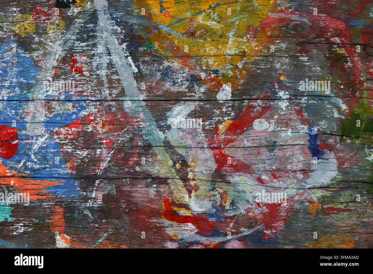 Blaue, rote, orange und gelbe Farbflecken auf einer verwitterten Holzoberfläche, dick geschichtete Textur, abstrakter Hintergrund Stockfoto