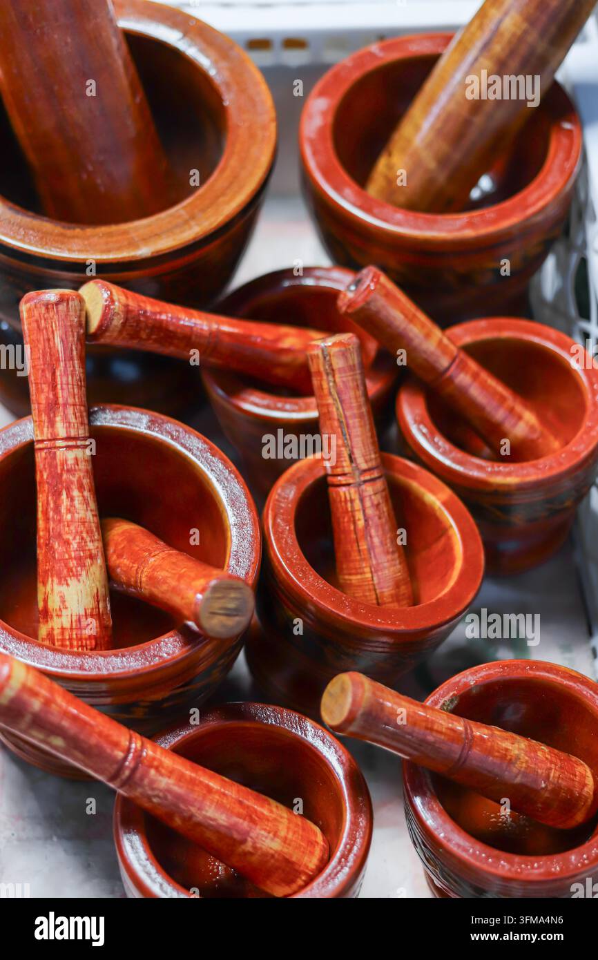 Holzliche Mörser und Stößel-Sets in verschiedenen Größen, ausgestellt auf dem Chatuchak-Markt in Bangkok, zeigen natürliche Holzmaserung und polierte Holzoberflächen. Stockfoto