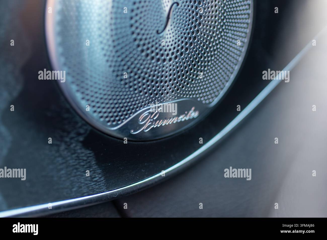 Burmester-Logo und metallischer Lautsprechergrill zeigen das Premium-Audio-System für Autos Stockfoto