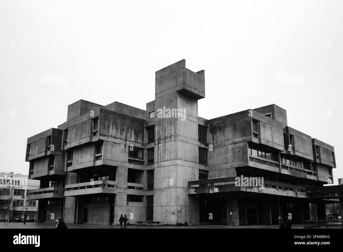 Monolithisches brutalistisches Betongebäude vor klarem Himmel mit rohen freigelegten Betontexturen, blockhaften geometrischen Formen und imposanter urbaner Architektur Stockfoto