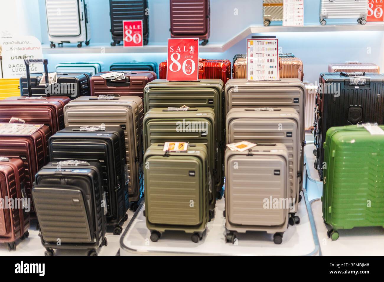 Bangkok, Thailand, 4. Mai 2026: Reihen von farbenfrohen Rollkoffern füllen eine Gepäckauslage im Einzelhandel, mit auffälligen Verkaufsschildern. Stockfoto
