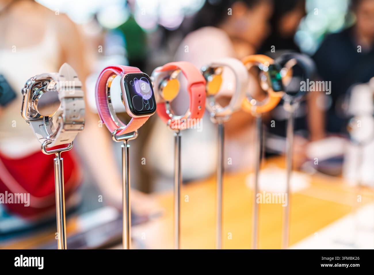 Bangkok, Thailand, 4. Mai 2026: Apple Watches stehen auf Displaystangen in einem Apple Store, wobei die Menschen im Hintergrund sanft verschwommen sind. Stockfoto