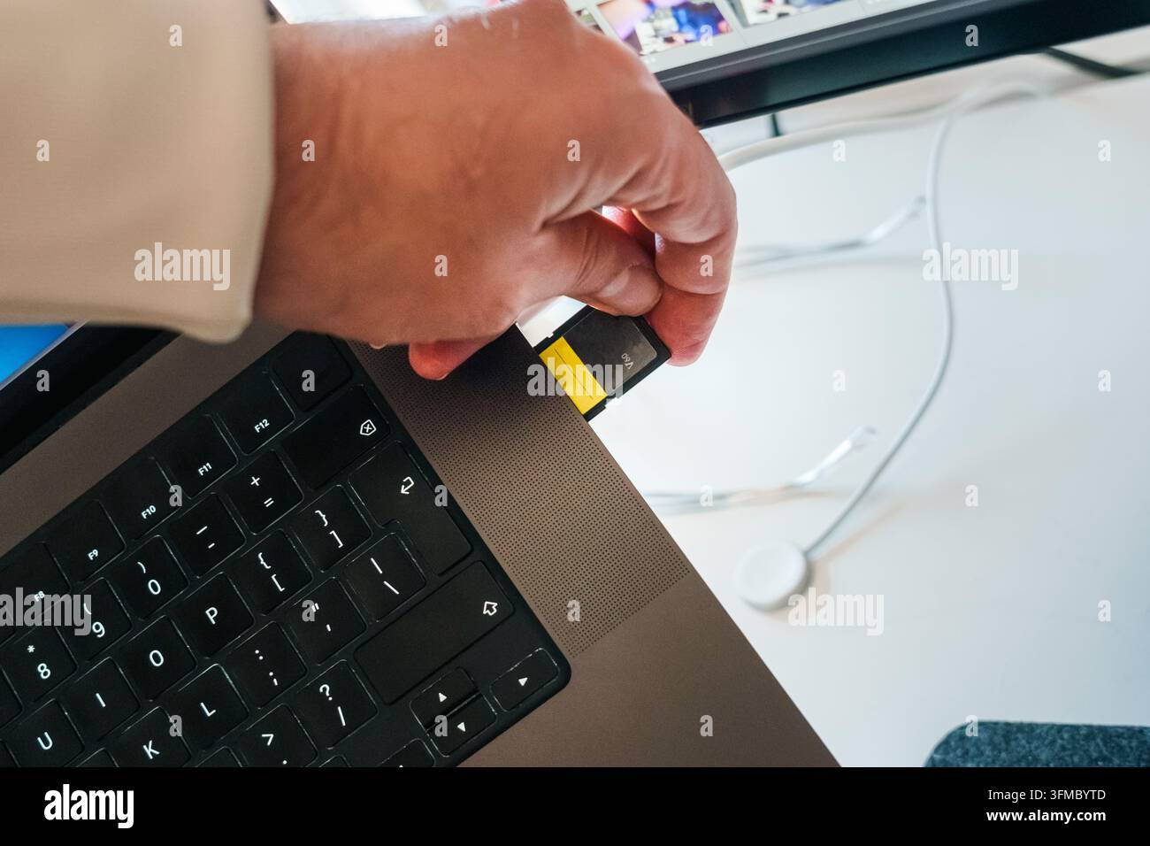 Laptopp Speicherkartenleser, bei dem eine SD-Karte eingelegt wird, um Daten zu speichern und Material zu sichern. Eine hochkapazitive digitale Speicherkarte wird in einen modernen Computerleser eingelegt Stockfoto