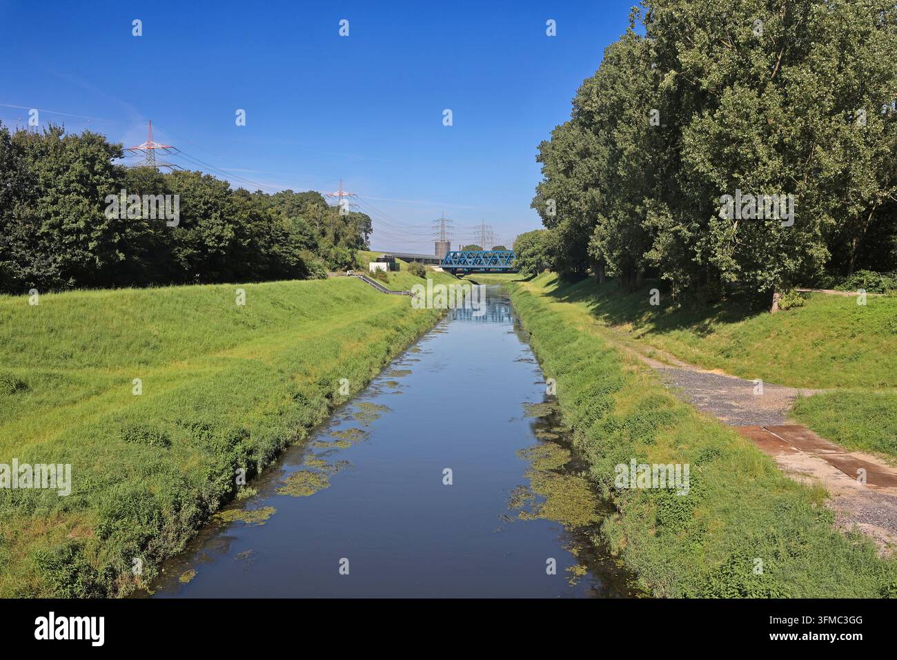 Die wieder natürlich gewordene Emscher, die nun ohne jegliche Abwasserableitung durch die Landschaft fließt, ist stellenweise von Verkehrswegen und Industrie eingerahmt. Nordrhein-Westfalen, Deutschland Stockfoto