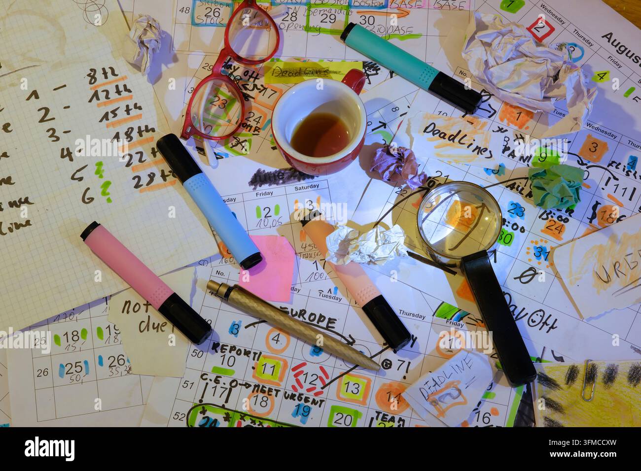 Kalender mit Geschäftsterminen und Fristen, Stiften, Kaffeetasse und Brille, monatlicher Zeitplan. Geschäftskonzept den Zeitplan schlagen. Stockfoto