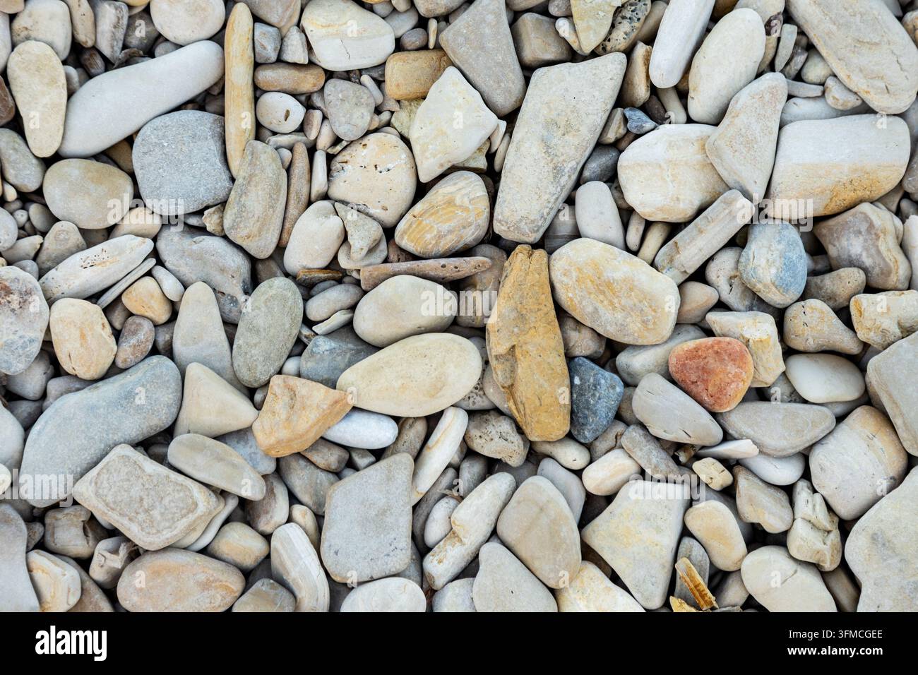 Flacher Hintergrund aus glatten bunten Flusssteinen Stockfoto