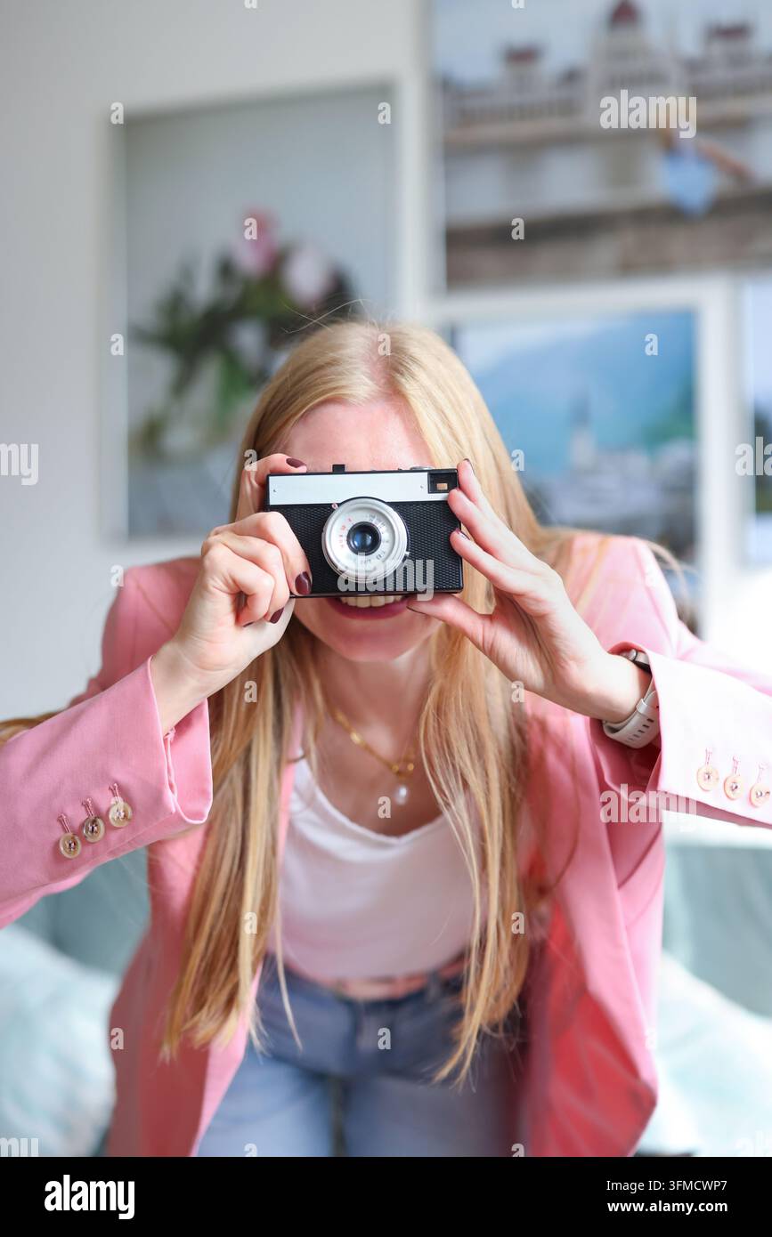 Junge Frau erforscht analoge Fotografie, veranschaulicht Kreativität, Nostalgie, achtsame Hobbys und authentische Inhaltsgestaltung. Stockfoto