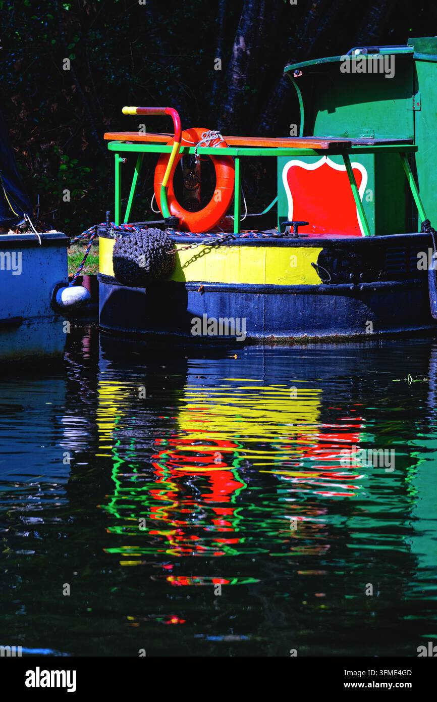 Interessante abstrakte Muster und Formen, die durch die Reflexionen auf dem Wasser eines farbenfrohen, bemalten Kanalschiffes auf dem River Wey Kanal New Haw Surrey gebildet werden Stockfoto
