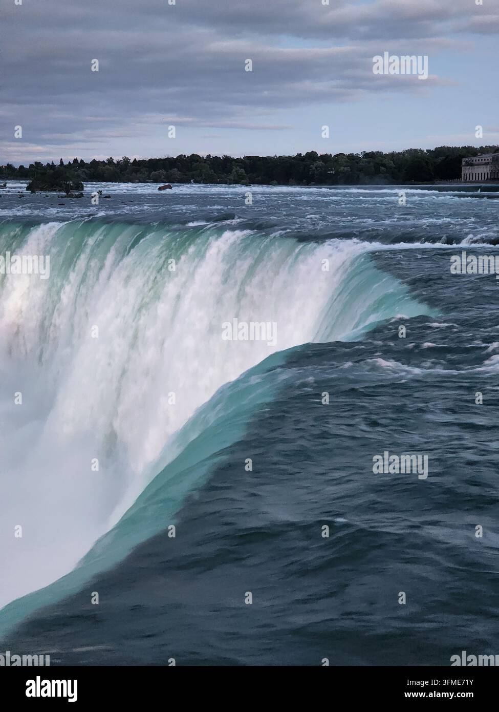 Hochwinkliger Nahaufnahme des Randes der Horseshoe Falls, die mächtige türkisfarbene Wasser über den Rand fließen lässt. - Smartphone-aufgenommenes Stockfoto
