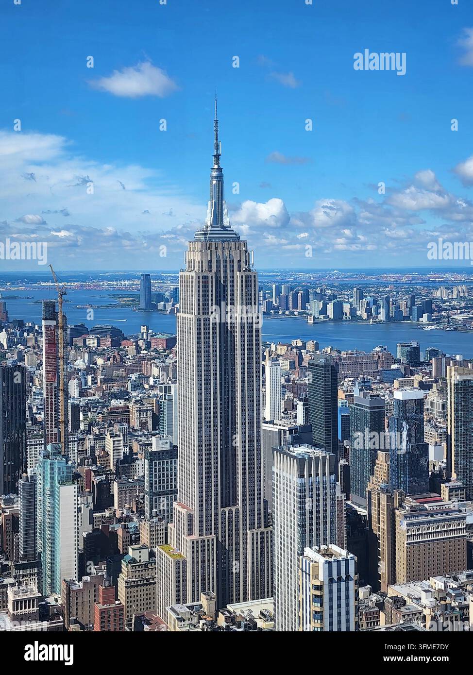 NEW YORK CITY - 27. JUNI 2024: Nahaufnahme der Luftaufnahme des ikonischen Wolkenkratzers Empire State Building in Midtown Manhattan. - Smartphone-aufgenommenes Stockfoto