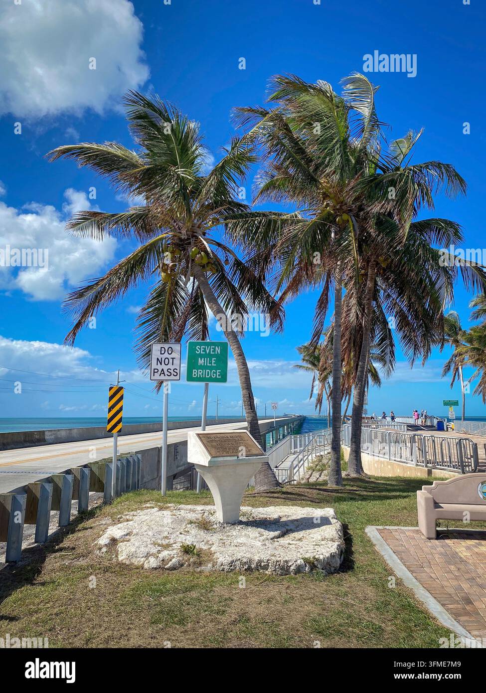 Anfang der Seven Mile Bridge, Florida, USA mit Touristeninformationsschild, Palmen und Gehweg vor blauem Himmel Stockfoto