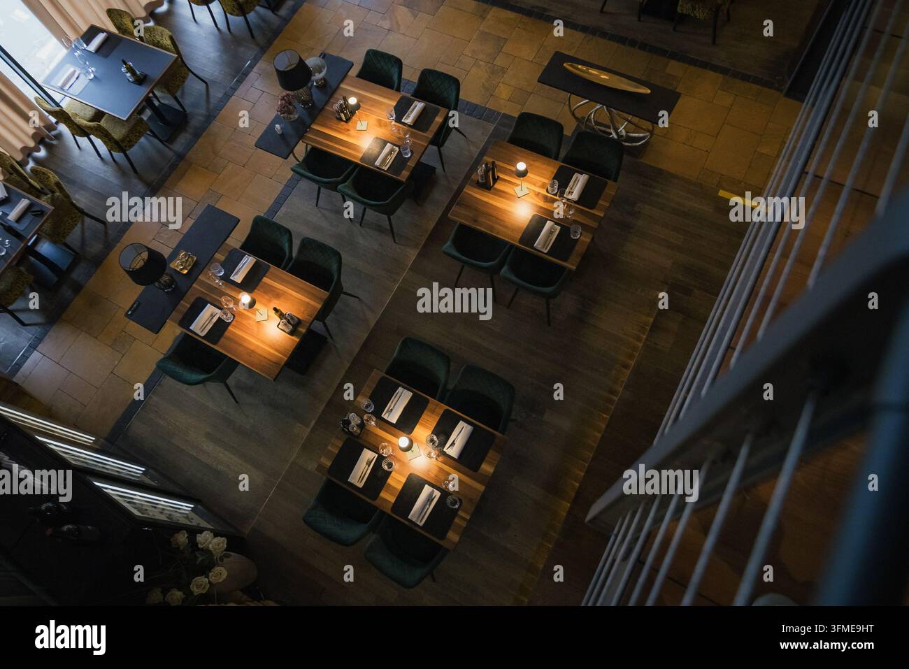 Stilvoller Essbereich eines gemütlichen modernen Restaurants, rustikales und zeitgenössisches Design mit Holztischen und warmer Beleuchtung, Ansicht von oben. Stockfoto
