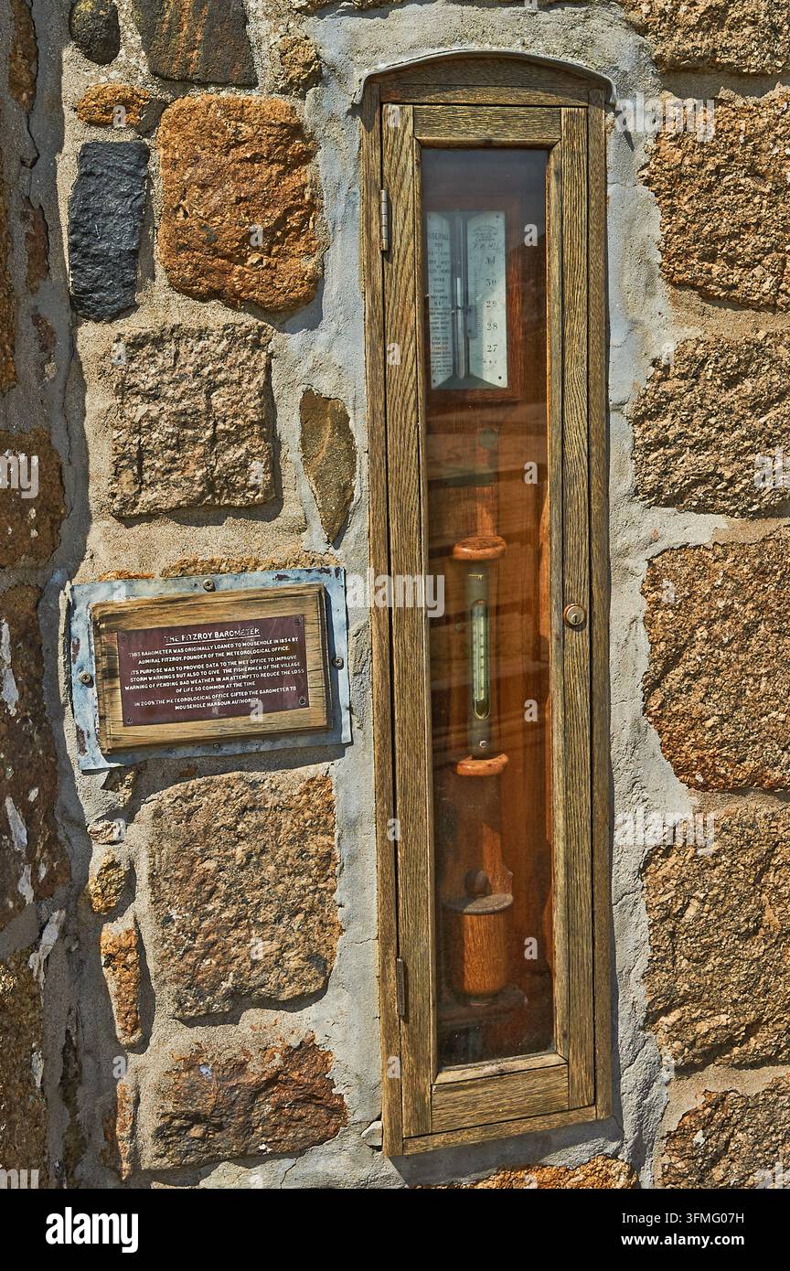Das historische Fitzroy-Barometer ist das öffentliche Wettermessgerät in Mousehole, Cornwall. Das Messgerät befindet sich in der Wand des Ship Inn. Stockfoto
