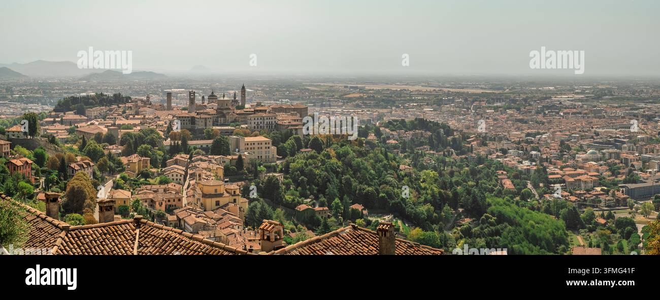 Panoramablick auf die Stadt von San Vigilio aus an einem heißen, schwülen Sommertag; im Hintergrund, in der Ebene, die Landebahn des internationalen Flughafens Orio al Serio Stockfoto