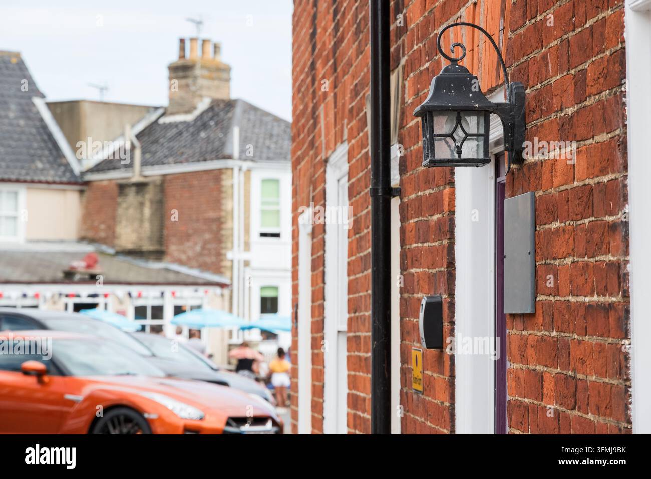 Außenwandlampe an der Ziegelmauer eines Reihenhauses in Southwold, England Stockfoto