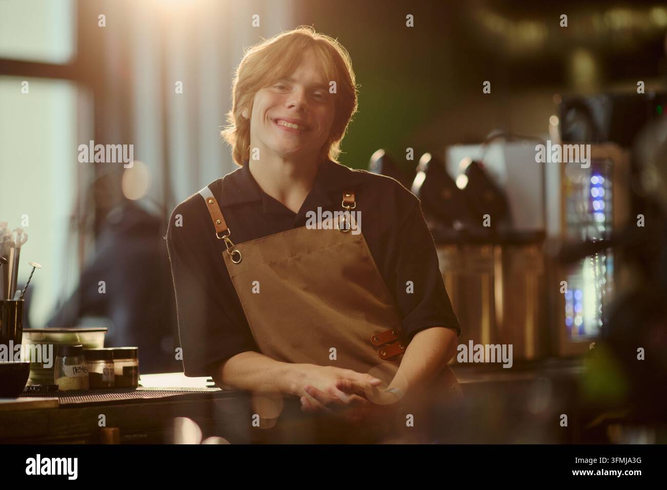 Porträt eines lächelnden Barista, der hinter der Theke in einem Café steht Stockfoto
