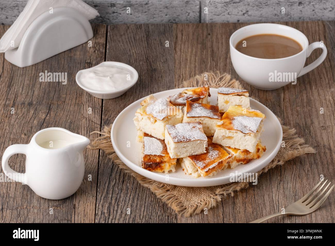 Leckeres Gebäck mit Kaffee und Sahne auf Holztablett Stockfoto