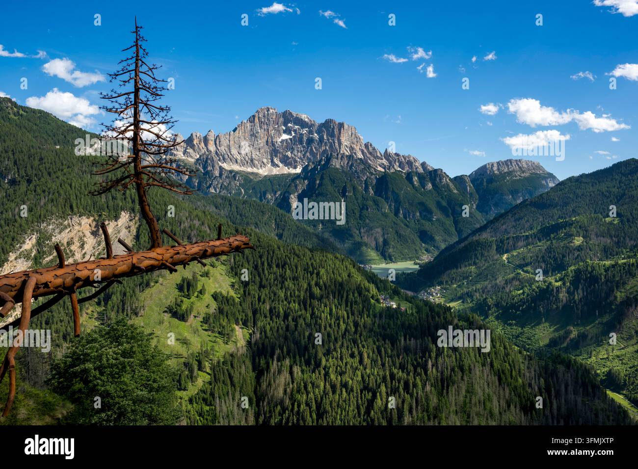 Italien, Veneto, Provinz Belluno, Aussichtspunkt Colle Santa Lucia, Sfida (Herausforderung) eine schmiedeeiserne Baumskulptur (2020) des Künstlers Valentino Moro, Seeblick auf den Lago Alleghe mit Monte Civetta im Hintergrund Stockfoto