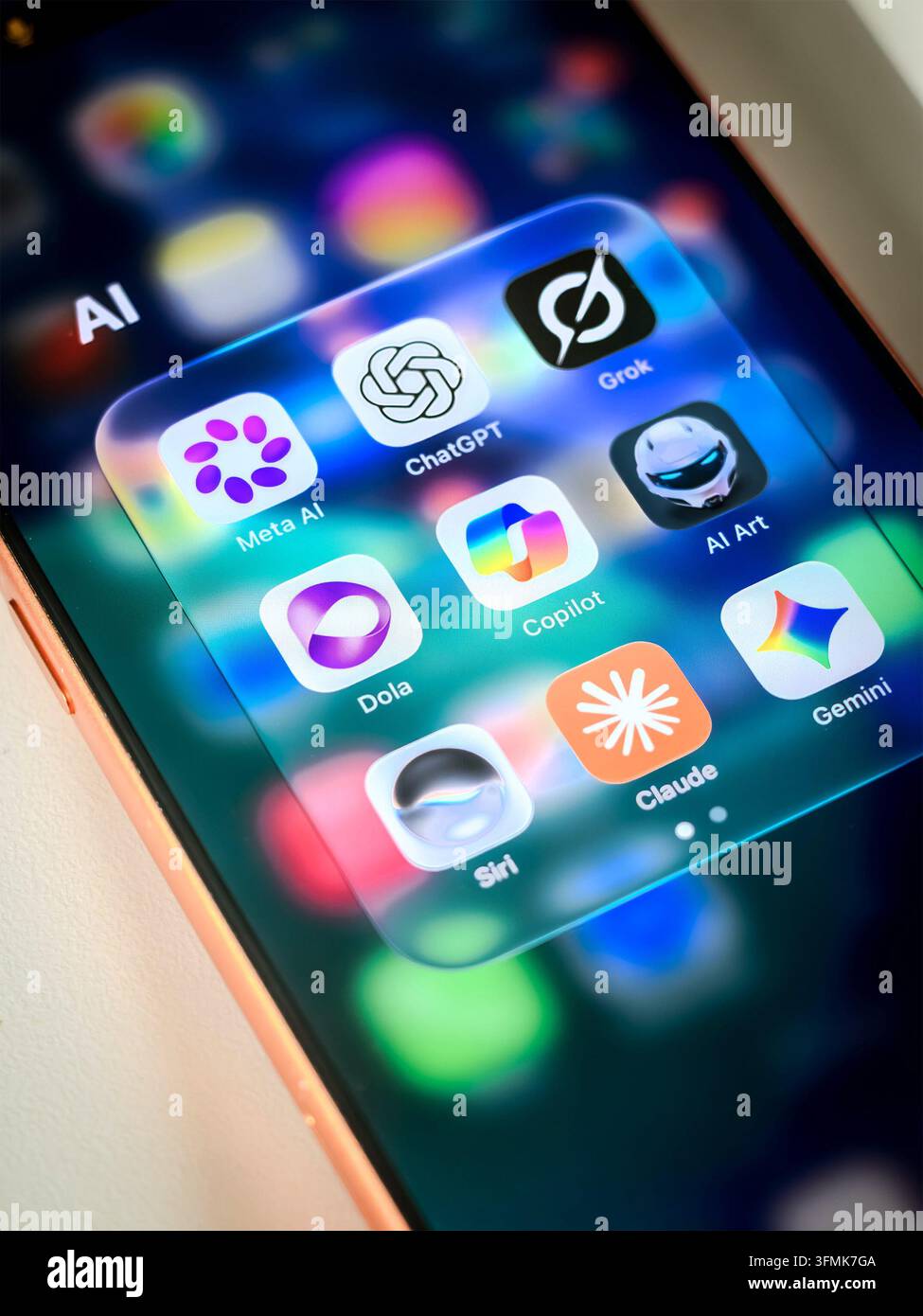 Smartphone-Bildschirm mit Ordner, der Symbole für KI-Anwendungen wie ChatGPT Meta AI Grok Copilot Claude Gemini Siri enthält Stockfoto