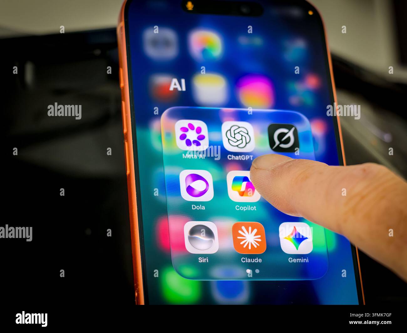 Finger berührt Smartphone-Bildschirm mit Ordner von KI-App-Symbolen einschließlich ChatGPT, Claude, Meta AI, Grok, Dola und Siri Stockfoto