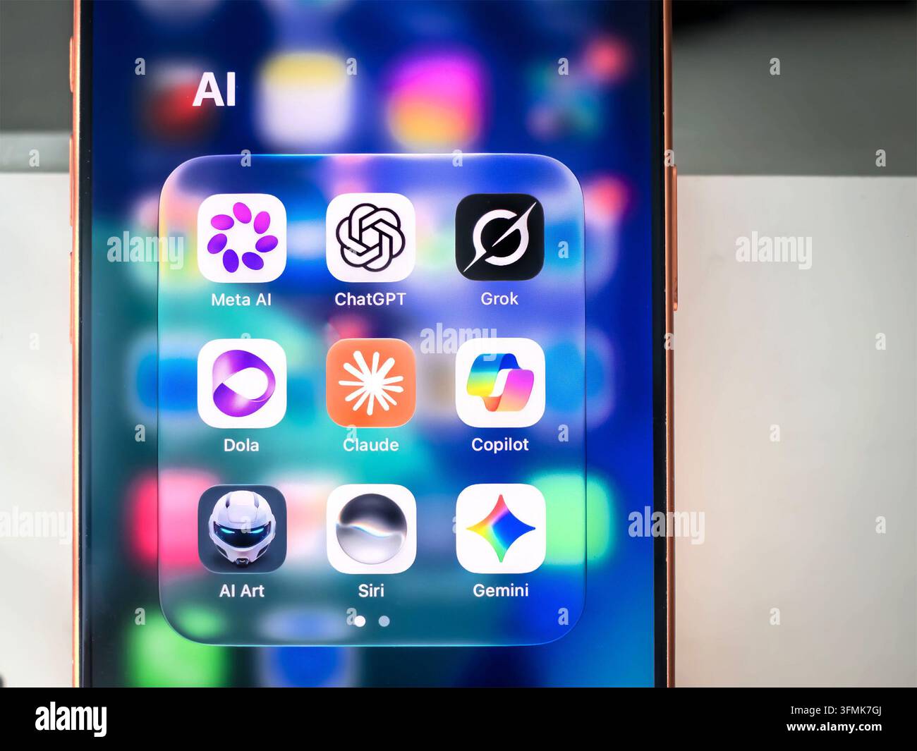 Smartphone-Bildschirm mit Ordner, der Symbole für KI-Anwendungen wie ChatGPT Meta AI Grok Copilot Claude Gemini Siri enthält Stockfoto