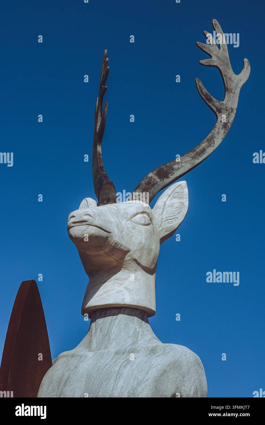 Die ikonische Hirsch-Surfer-Statue in Nazare, Portugal vor einem lebendigen blauen Himmel. Stockfoto